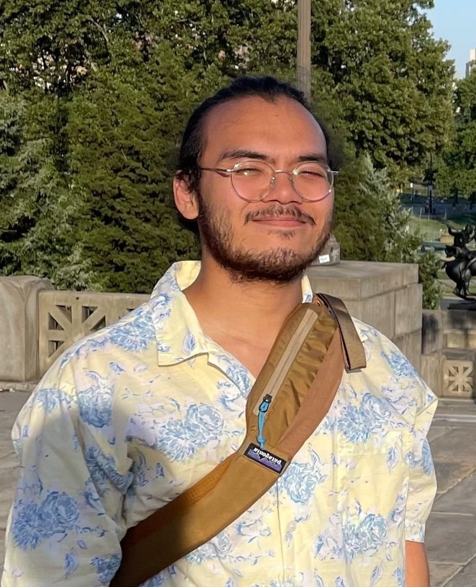 A BU graduate student worker with a patterned shirt and glasses.