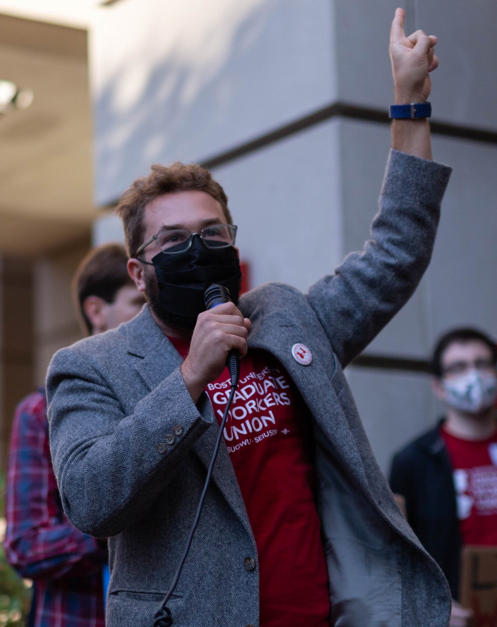 A BU grad worker holding a microphone at a rally